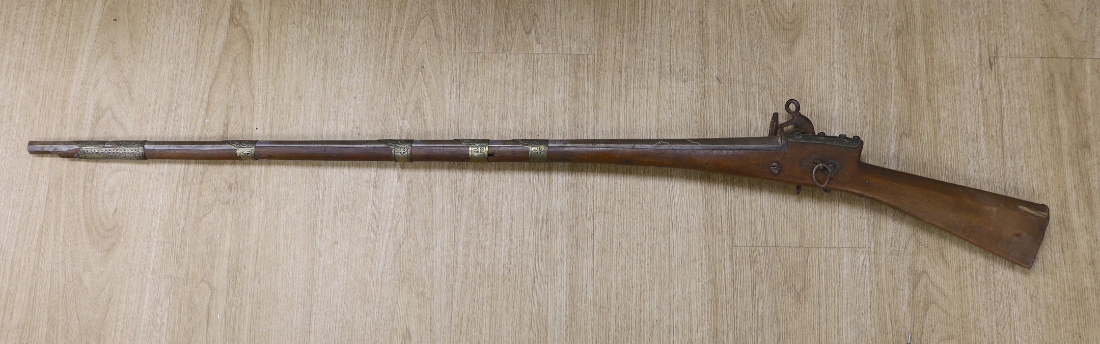 An Eastern decoratively metal mounted antique musket, 132cms long.